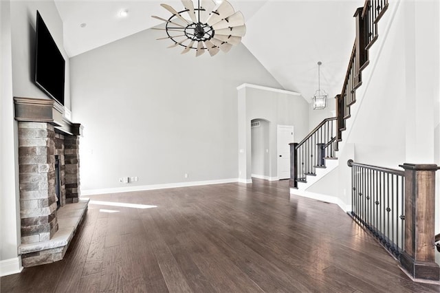 704 SW Admiral Byrd Dr, Lees Summit, MO 64082 - unfurnished living room with a chandelier, high vaulted ceiling, arched walkways, wood finished floors, and stairs