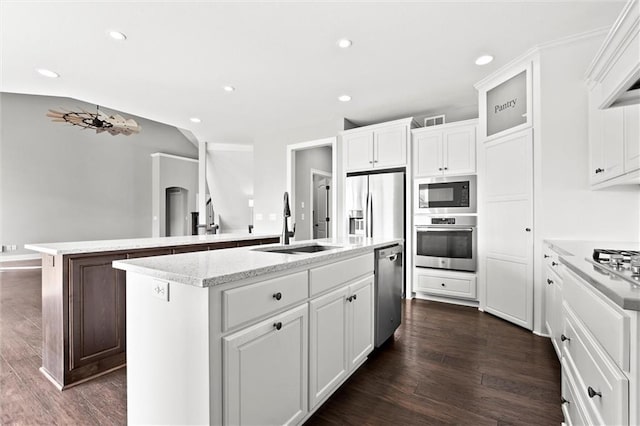 704 SW Admiral Byrd Dr, Lees Summit, MO 64082 - kitchen with appliances with stainless steel finishes, an island with sink, recessed lighting, dark wood-style floors, and white cabinetry