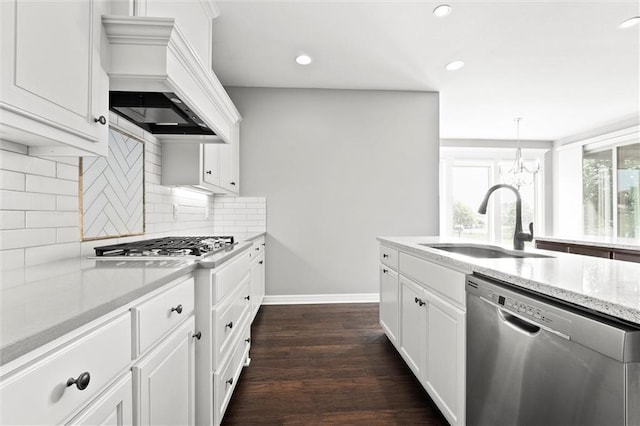 704 SW Admiral Byrd Dr, Lees Summit, MO 64082 - kitchen with stainless steel appliances, custom range hood, decorative backsplash, light stone countertops, and a chandelier
