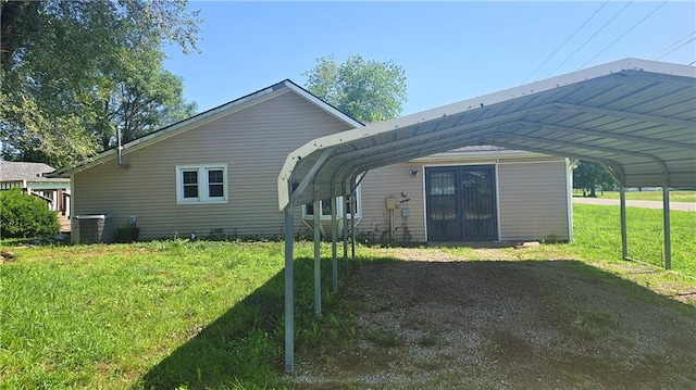 1443 215th St, Fort Scott, KS 66701 - back of house featuring a detached carport and a lawn