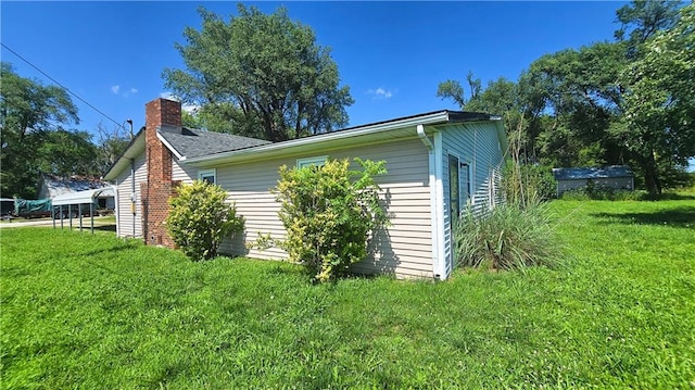 1443 215th St, Fort Scott, KS 66701 - view of property exterior featuring a chimney and a yard