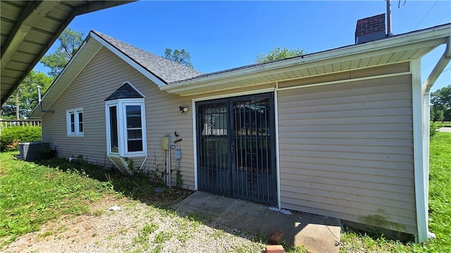 1443 215th St, Fort Scott, KS 66701 - property entrance featuring a chimney and roof with shingles