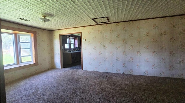 1443 215th St, Fort Scott, KS 66701 - carpeted spare room featuring wallpapered walls and ornamental molding