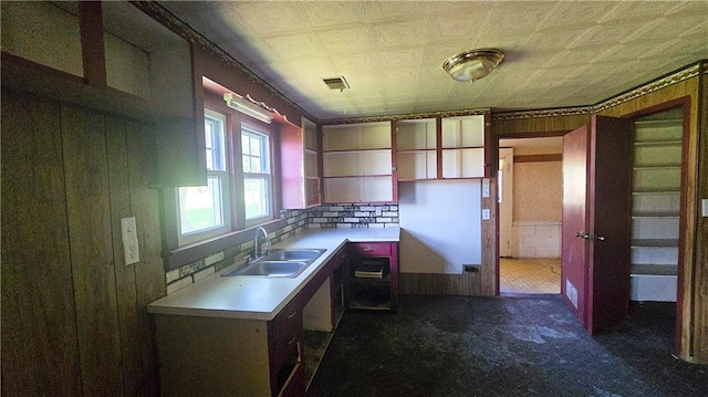 1443 215th St, Fort Scott, KS 66701 - kitchen featuring dark colored carpet, light countertops, wood walls, and open shelves