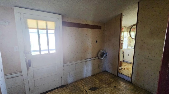 1443 215th St, Fort Scott, KS 66701 - doorway to outside featuring tile patterned floors and wallpapered walls