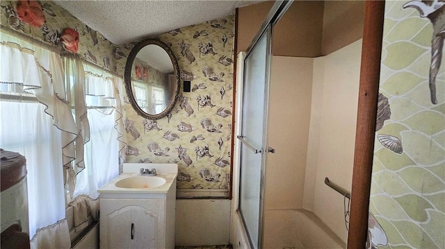 1443 215th St, Fort Scott, KS 66701 - bathroom with wallpapered walls, a shower with shower door, vanity, and a textured ceiling
