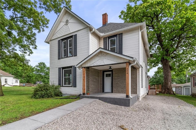306 W 4th St, Cameron, MO 64429 - traditional-style home featuring covered porch, a chimney, a front lawn, and brick siding