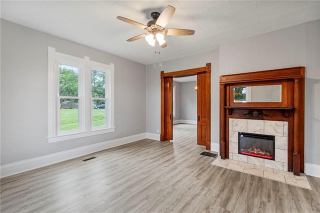 306 W 4th St, Cameron, MO 64429 - unfurnished living room featuring wood finished floors, ceiling fan, and a fireplace