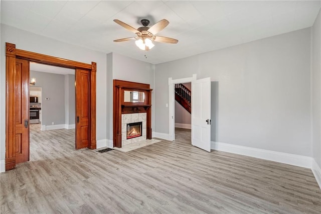 306 W 4th St, Cameron, MO 64429 - unfurnished room with light wood-style floors, ceiling fan, and a fireplace