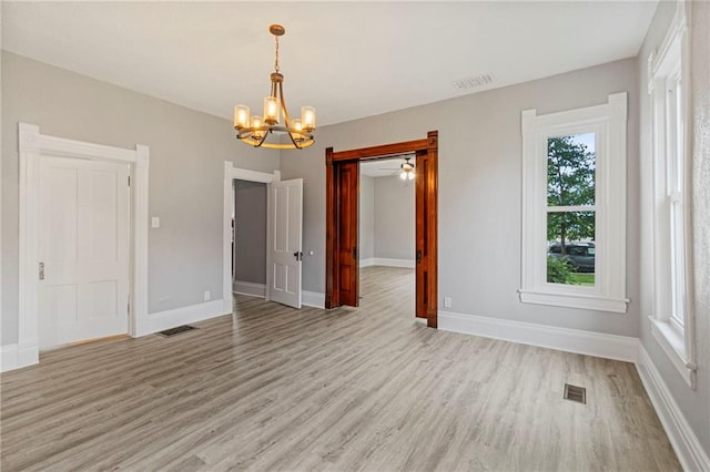 306 W 4th St, Cameron, MO 64429 - empty room with a chandelier, light wood finished floors, and plenty of natural light