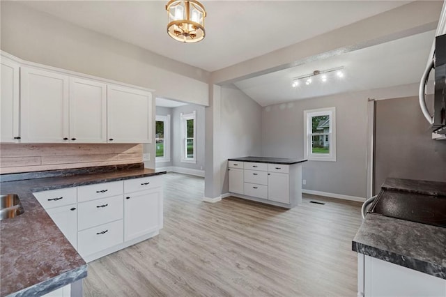 306 W 4th St, Cameron, MO 64429 - kitchen featuring light wood-type flooring, dark countertops, and white cabinetry
