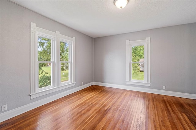 306 W 4th St, Cameron, MO 64429 - spare room featuring wood finished floors and a textured ceiling