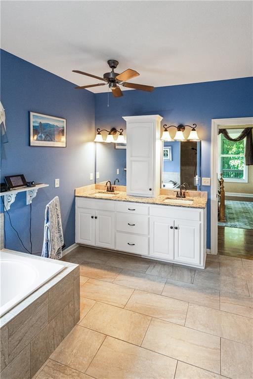 1310 Norfolk Dr, Harrisonville, MO 64701 - full bathroom with double vanity, a ceiling fan, and tiled bath