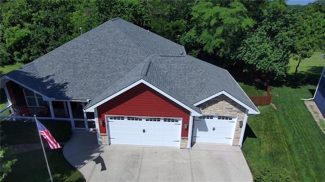 1310 Norfolk Dr, Harrisonville, MO 64701 - view of front facade with stone siding, a shingled roof, a front lawn, driveway, and an attached garage