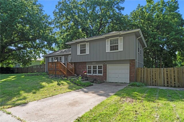 331 E 100th Ter, Kansas City, MO 64114 - split level home featuring brick siding, a garage, and concrete driveway