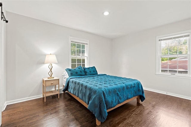 331 E 100th Ter, Kansas City, MO 64114 - bedroom with wood finished floors, a barn door, and recessed lighting