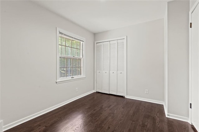 331 E 100th Ter, Kansas City, MO 64114 - unfurnished bedroom featuring dark wood finished floors and a closet