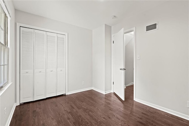 331 E 100th Ter, Kansas City, MO 64114 - unfurnished bedroom with dark wood finished floors and a closet