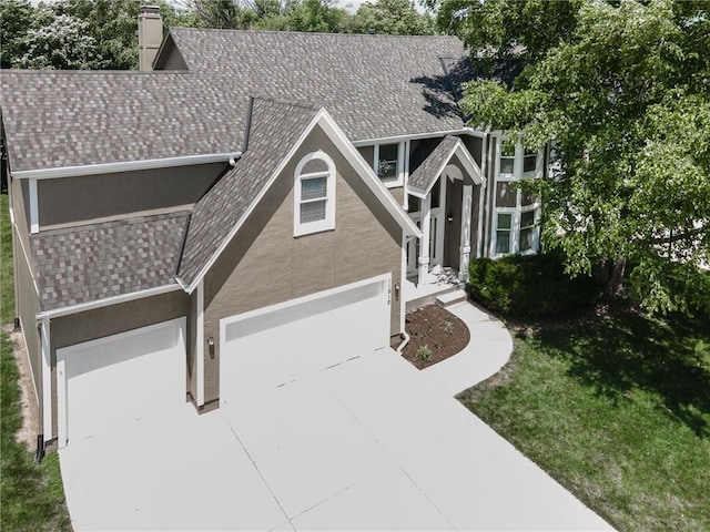 11912 W 132nd St, Overland Park, KS 66213 - view of front of house featuring stucco siding, concrete driveway, a front yard, a garage, and a chimney