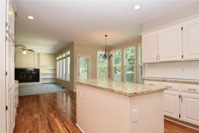 11912 W 132nd St, Overland Park, KS 66213 - kitchen with healthy amount of natural light, a glass covered fireplace, open floor plan, a kitchen island, and recessed lighting