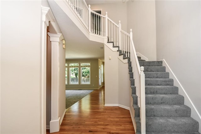 11912 W 132nd St, Overland Park, KS 66213 - stairs featuring wood finished floors, a towering ceiling, and ornate columns