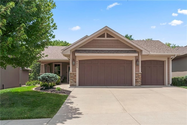 4890 NW Linder Ln, Riverside, MO 64150 - view of front facade with an attached garage, concrete driveway, stone siding, a front lawn, and a shingled roof