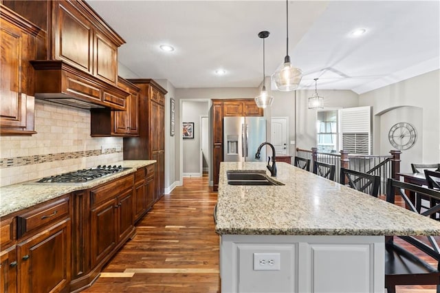 4890 NW Linder Ln, Riverside, MO 64150 - kitchen featuring stainless steel appliances, a center island with sink, tasteful backsplash, dark wood finished floors, and a breakfast bar