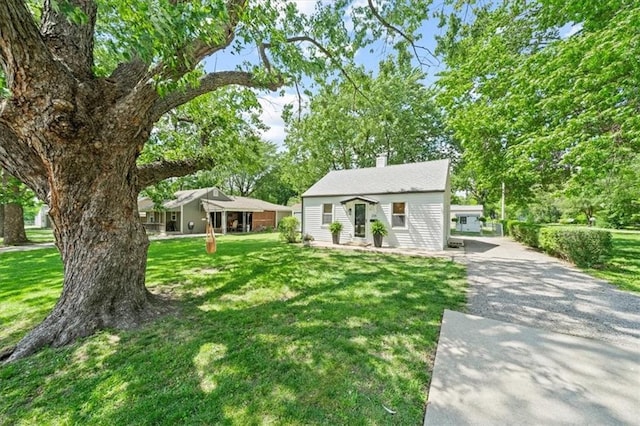 236 W Park St, Gardner, KS 66030 - view of front facade with a front yard, a chimney, and gravel driveway