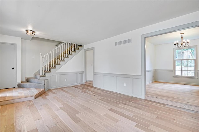 16117 W 125th Ter, Olathe, KS 66062 - spare room with wood finished floors, a chandelier, stairway, and wainscoting