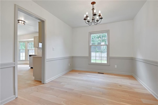 16117 W 125th Ter, Olathe, KS 66062 - empty room with a chandelier, healthy amount of natural light, and light wood-style flooring