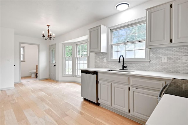 16117 W 125th Ter, Olathe, KS 66062 - kitchen featuring stainless steel dishwasher, light countertops, tasteful backsplash, a chandelier, and light wood-type flooring