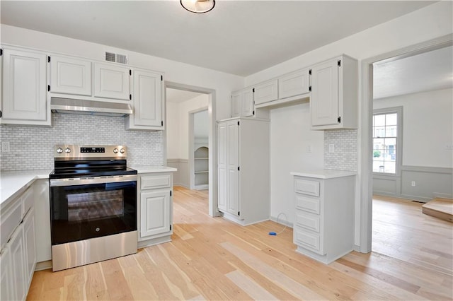 16117 W 125th Ter, Olathe, KS 66062 - kitchen with stainless steel range with electric stovetop, under cabinet range hood, light countertops, backsplash, and light wood finished floors
