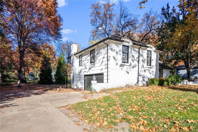 3322 W 95th St, Leawood, KS 66206 - view of side of property with a chimney, concrete driveway, an attached garage, and brick siding