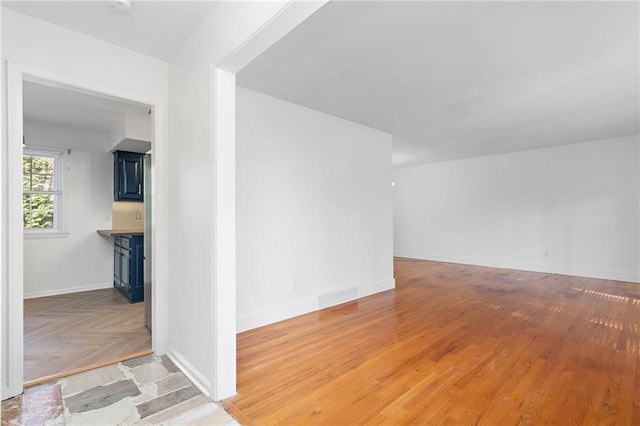 3322 W 95th St, Leawood, KS 66206 - unfurnished living room with baseboards and wood finished floors
