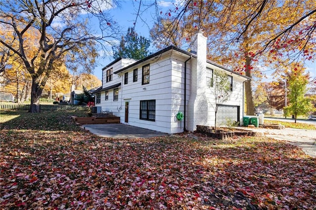 3322 W 95th St, Leawood, KS 66206 - view of side of property featuring an attached garage, a chimney, driveway, and a patio area