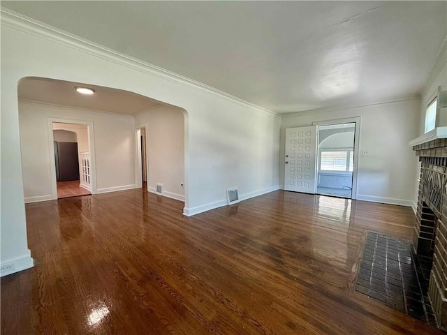 2416 E 70th St, Kansas City, MO 64132 - unfurnished living room featuring a fireplace, arched walkways, wood finished floors, and crown molding