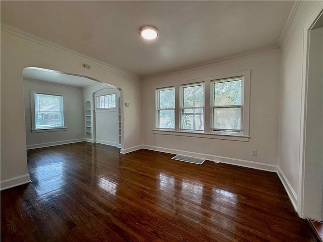 2416 E 70th St, Kansas City, MO 64132 - unfurnished living room with arched walkways, ornamental molding, and dark wood-type flooring