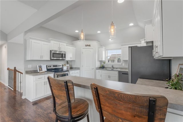 2712 E Sycamore St, Tonganoxie, KS 66086 - kitchen with appliances with stainless steel finishes, recessed lighting, a peninsula, dark wood finished floors, and white cabinetry