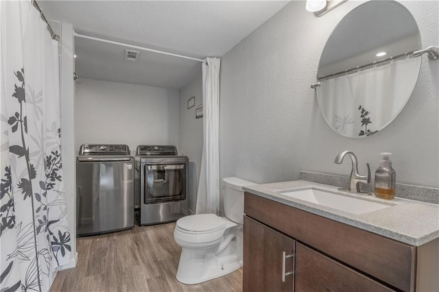2712 E Sycamore St, Tonganoxie, KS 66086 - bathroom with washing machine and dryer, wood finished floors, and vanity