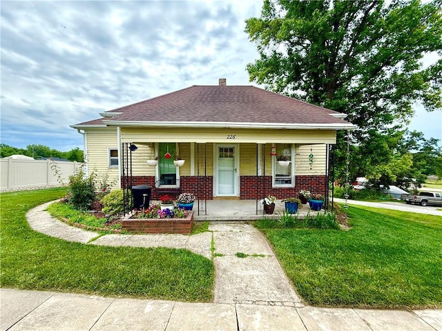 226 Mckenzie St, Barnard, MO 64423 - bungalow with brick siding, covered porch, and roof with shingles