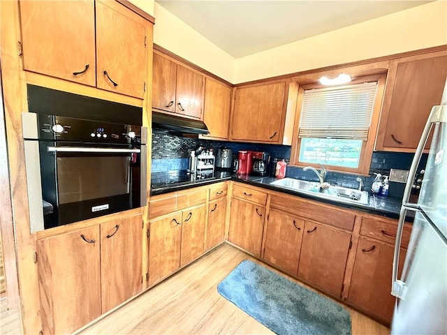 226 Mckenzie St, Barnard, MO 64423 - kitchen with black appliances, dark countertops, under cabinet range hood, and light wood-type flooring