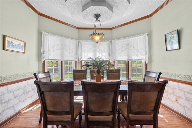3602 S Sweeney Rd, Grain Valley, MO 64029 - dining room featuring a wainscoted wall, wood-type flooring, a textured ceiling, and ornamental molding