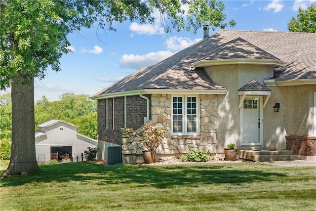 3602 S Sweeney Rd, Grain Valley, MO 64029 - back of property with stone siding, a yard, stucco siding, a shingled roof, and a garage