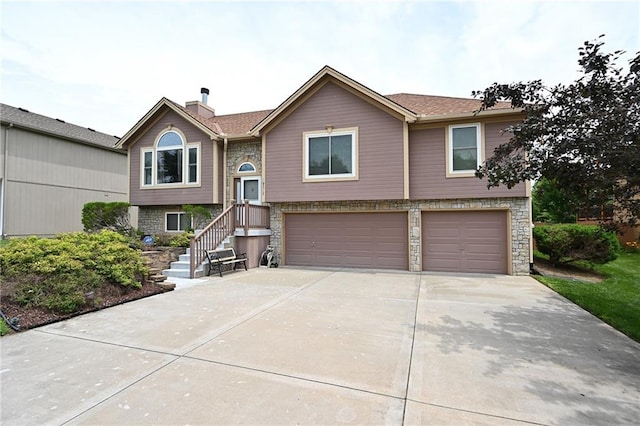 19617 Harbor Dr, Smithville, MO 64089 - split foyer home with an attached garage, concrete driveway, a chimney, and stone siding