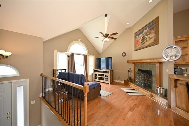 19617 Harbor Dr, Smithville, MO 64089 - living area with a tile fireplace, wood finished floors, a ceiling fan, and high vaulted ceiling