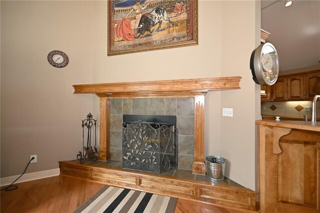 19617 Harbor Dr, Smithville, MO 64089 - detailed view of wood finished floors, a tiled fireplace, and tasteful backsplash