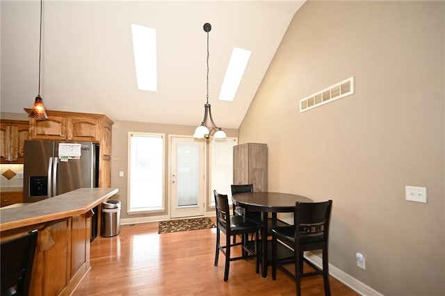 19617 Harbor Dr, Smithville, MO 64089 - dining area with a skylight, light wood-style floors, and high vaulted ceiling