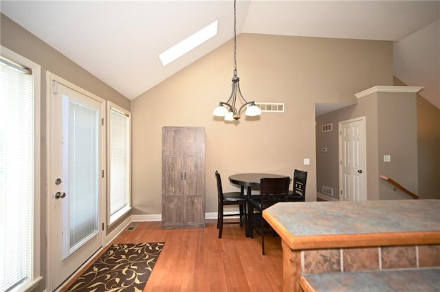 19617 Harbor Dr, Smithville, MO 64089 - dining area featuring a skylight, a chandelier, wood finished floors, and high vaulted ceiling