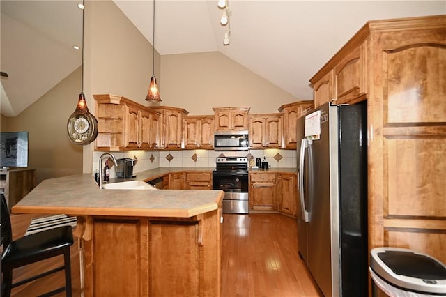 19617 Harbor Dr, Smithville, MO 64089 - kitchen featuring stainless steel appliances, a peninsula, lofted ceiling, light wood-style floors, and decorative backsplash