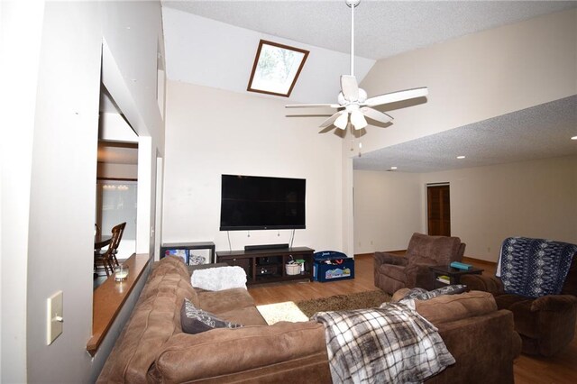 211 Southside Ct, Excelsior Springs, MO 64024 - living room with a ceiling fan, wood finished floors, high vaulted ceiling, and a skylight